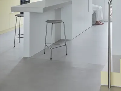 現代極簡廚房，配有混凝土檯面與吧台椅。