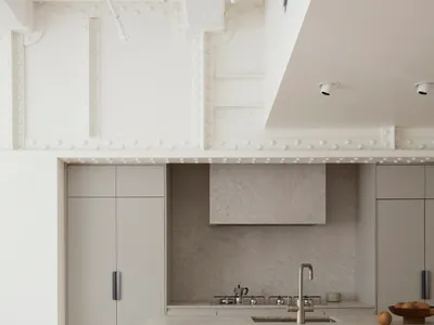 Modern, minimalist kitchen featuring a concrete countertop and sleek, gray cabinetry.