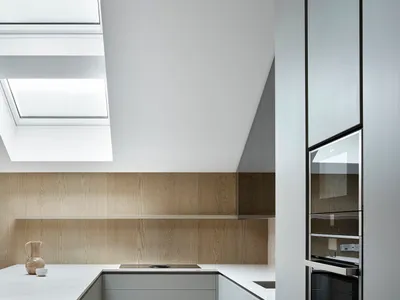 A modern kitchen with white marble countertops and stainless steel appliances.