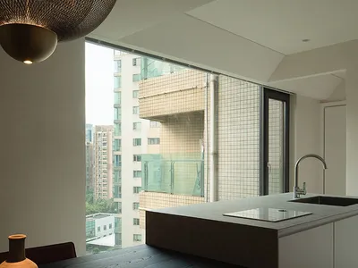 Contemporary residential kitchen featuring minimalist design, dark wooden countertops, and stainless steel appliances.