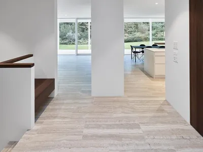 Interior view of a modern kitchen and dining area with marble floors and white walls.