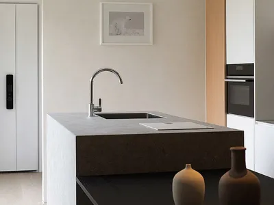 Modern minimalist kitchen with concrete countertop and white appliances.