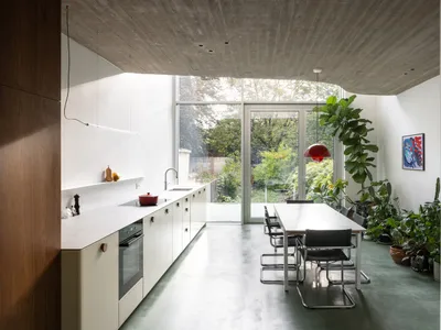 A sleek, modern kitchen with minimalist design features and a concrete floor.