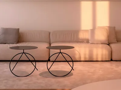 A minimalist living room featuring comfortable seating areas, console tables with unique metal bases, and a sleek, modern des