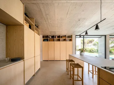 Minimalist residential kitchen featuring wooden cabinets and open shelves.