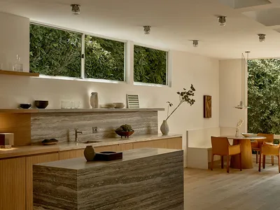 A modern minimalist kitchen featuring granite countertops and open shelving.