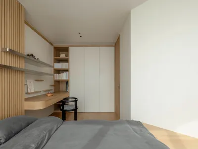 A minimalist bedroom with wooden and metallic elements, including a bed, shelves, and a closet.
