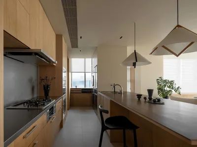 Contemporary kitchen with wooden cabinets, black countertops, and a large island.