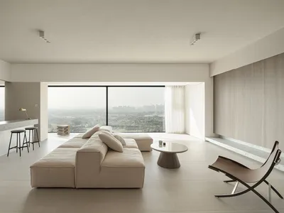 Modern minimalist living room with concrete elements and a panoramic view.