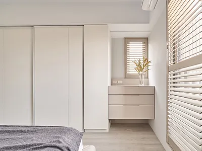 Modern minimalist bedroom featuring wooden furniture and light, neutral color palette