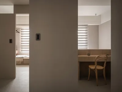 A minimalist bedroom with neutral tones and modern furniture.