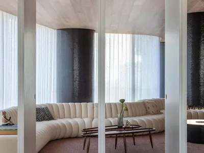 A modern living room with a curved sofa and textured cushions.