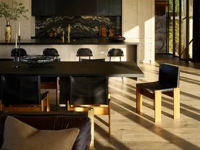 Contemporary residential kitchen dining area featuring wooden paneling and a black marble kitchen island.