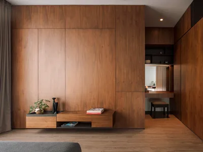 A minimalist bedroom with wooden walls, floors, and furniture.