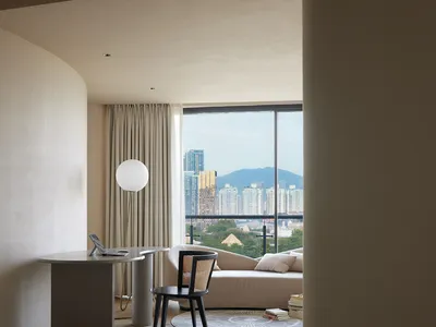 Modern minimalist bedroom featuring concrete walls, wooden furniture, and fabric finishes.