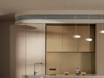 Modern, minimalist residential kitchen with concrete countertops and wooden stools.