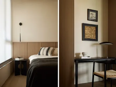 A modern minimalist bedroom featuring natural wood elements, with a bed and nightstand by a window with blinds.