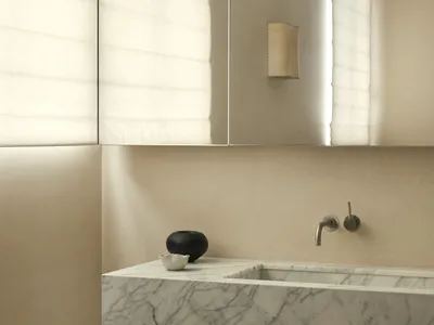 Modern minimalist bathroom featuring a white marble countertop with integrated sink and a neutral color palette.