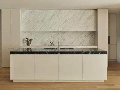 Modern kitchen with marble countertops and backsplash in a residential setting.