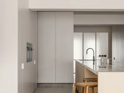 Modern minimalist kitchen with sleek lines, clean surfaces, and a long island.