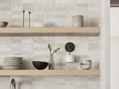 Minimalist kitchen with white cabinets, wooden shelves, ceramic tiles, and marble countertop.