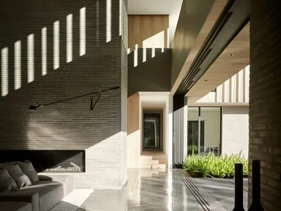 Contemporary living room featuring concrete walls, minimalist furniture, and natural light.