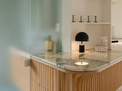 A minimalist interior with a wooden counter featuring a marble countertop.