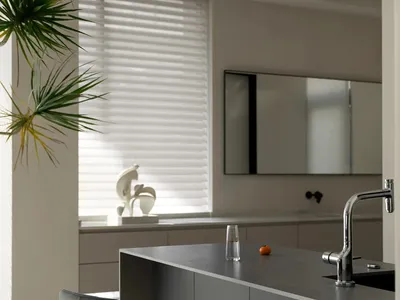 A modern minimalist kitchen with sleek, grey cabinets and a concrete countertop.
