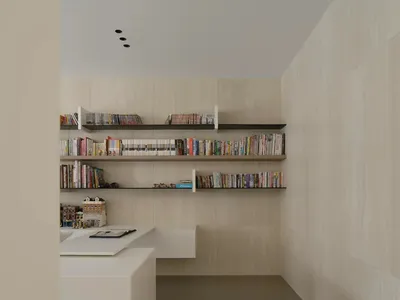 一間井然有序的現代居家辦公室，懸浮式書架上擺滿書籍，桌上放著筆記本和原子筆。