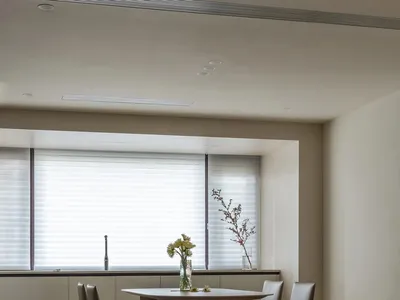 A modern kitchen featuring wooden cabinetry and a dining table with chairs.