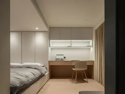 Modern neutral-toned bedroom interior design with concrete furniture and minimalistic decor.