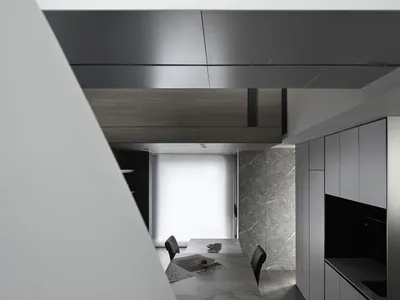 Modern, minimalist kitchen with marble countertops and wooden cabinets.