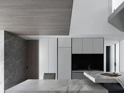 A modern kitchen interior with marble countertops and concrete elements.
