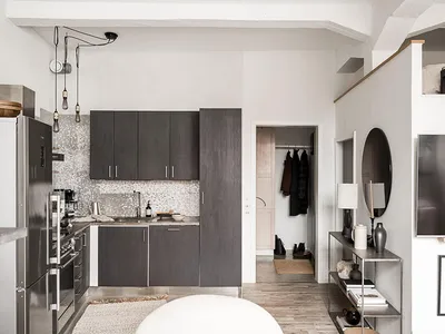 Modern, minimalist kitchen with dark wood cabinets, metal accents, and white backsplash.