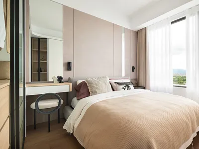 Modern bedroom with fabric bedding and wooden flooring.