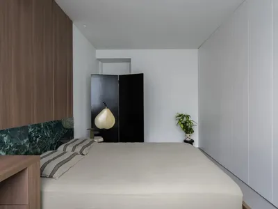 Modern bedroom interior with concrete walls and minimalist design elements.