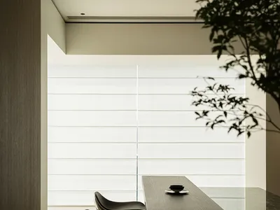 Modern kitchen with wooden counters, black leather stools, and glass window.