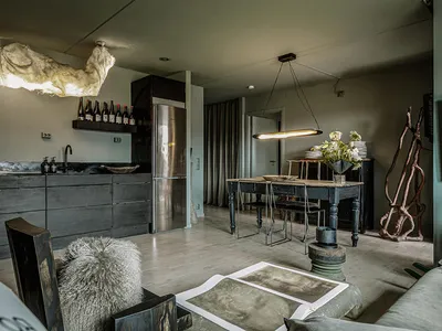 An industrial-style living room with metal furniture, concrete flooring, and wooden accents.