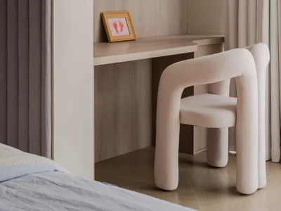 A modern wooden bedroom with a comfortable chair, shelves, and a clock.