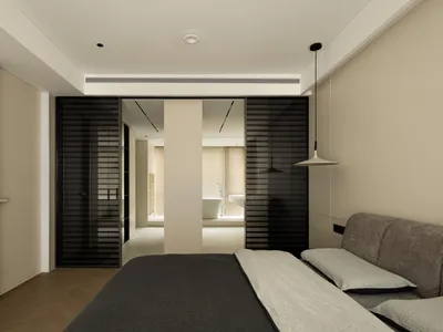 A minimalist bedroom with a bed, a sofa, and black blinds in a neutral-colored room