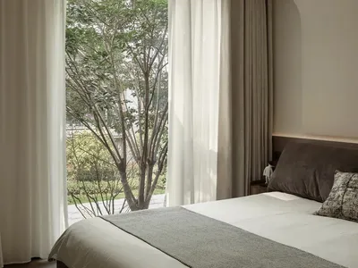 Minimalist bedroom featuring simple, elegant curtains.