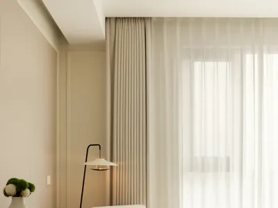 A modern minimalist bedroom featuring a minimalistic white armchair with a black frame sitting by a window with sheer curtain