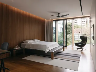 A modern minimalist bedroom featuring wood walls and a view of the outdoors.