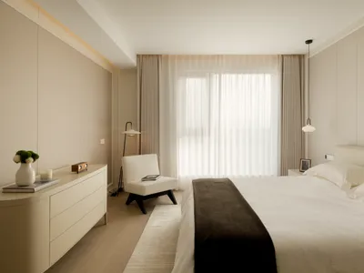 Spacious minimalist bedroom with modern furniture and glass window