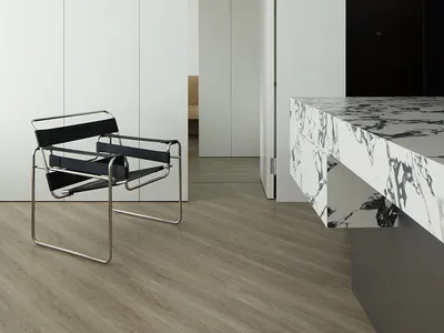 Minimalist living room with a marble countertop, white cabinets, a black chair, and a wood floor.