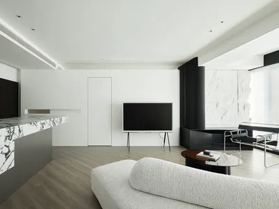 A modern living room featuring a white marble fireplace and a minimalist white sofa against a white wall.