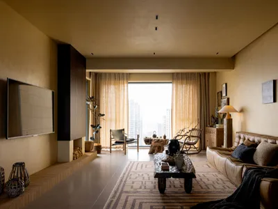 A chic living room with concrete walls, leather furniture, and industrial design elements.