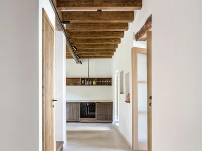 Modern minimalist kitchen with wooden accents and concrete floor.