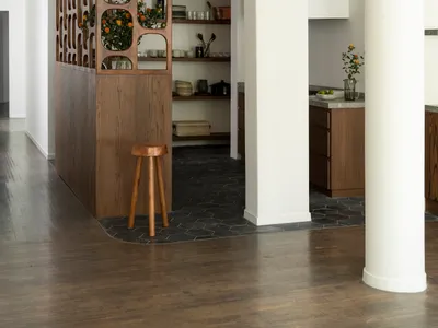 A modern kitchen with an open space design and wooden features, including white cabinets and brown wooden accents.