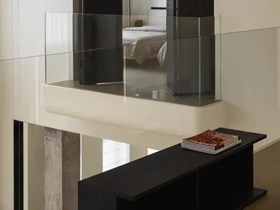A minimalist bedroom features glass partitions and a sleek interior design.